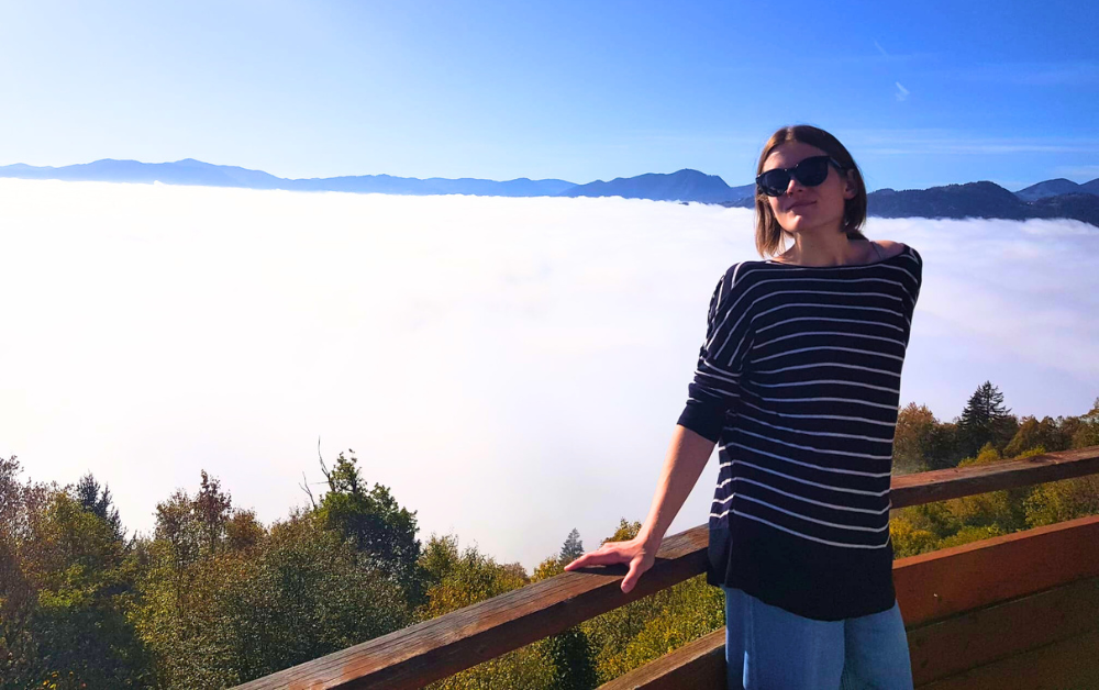 Image: Aurora Tjernshaugen stood on a mountain top with the clouds behind her.